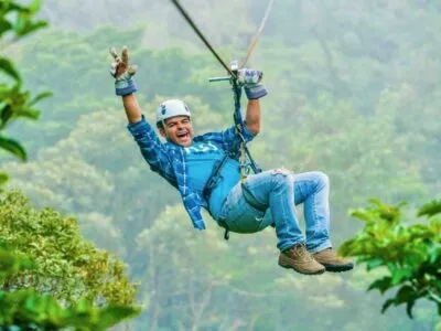 Monteverde zipline tour guest gliding and making peace sign