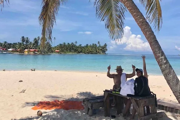 Isla Perro San blas couple on beach under palm tree 2 copy Isla Perro San blas couple on beach under palm tree
