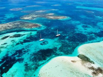 Aerial view of a turquoise reef, sandbar and sailboats on a Cayos Holandeses tour