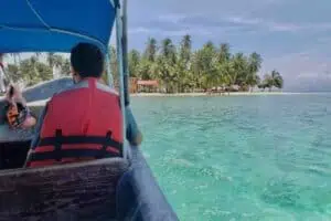 Isla Yansailadup San Blas Man Sitting In Boat Approaching Beach Isla Yansailadup San Blas man sitting in boat approaching beach