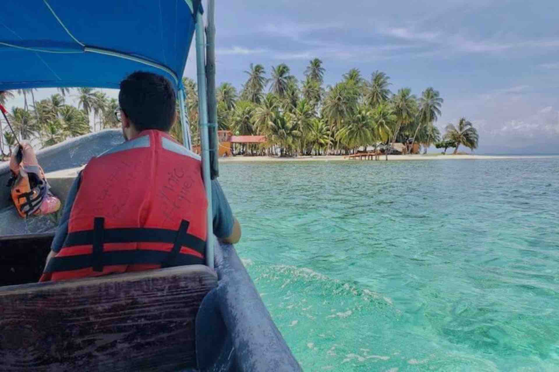 Isla Yansailadup San Blas man sitting in boat approaching beach
