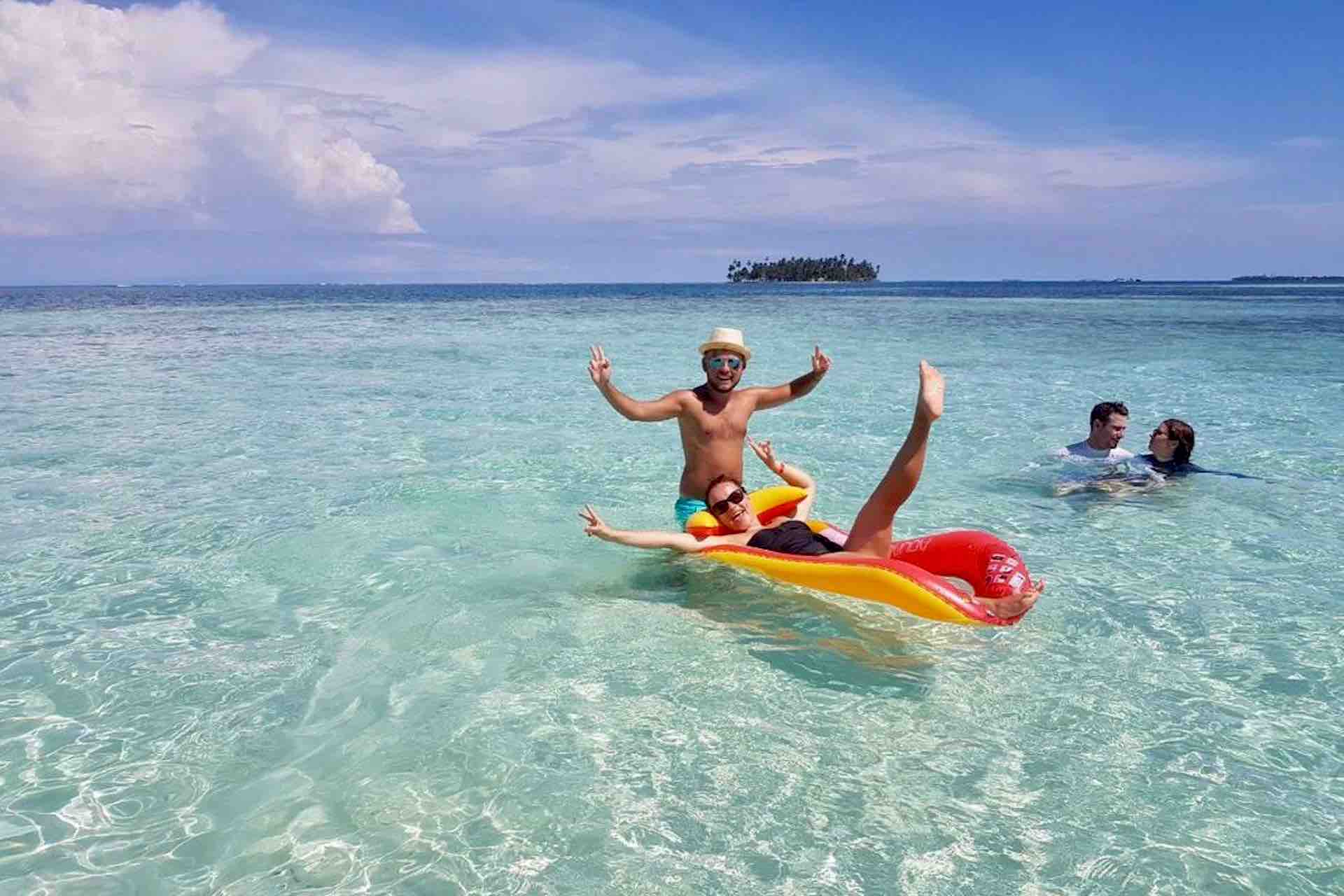 Isla Aroma San Blas tourists playing in shallow turquoise ocean
