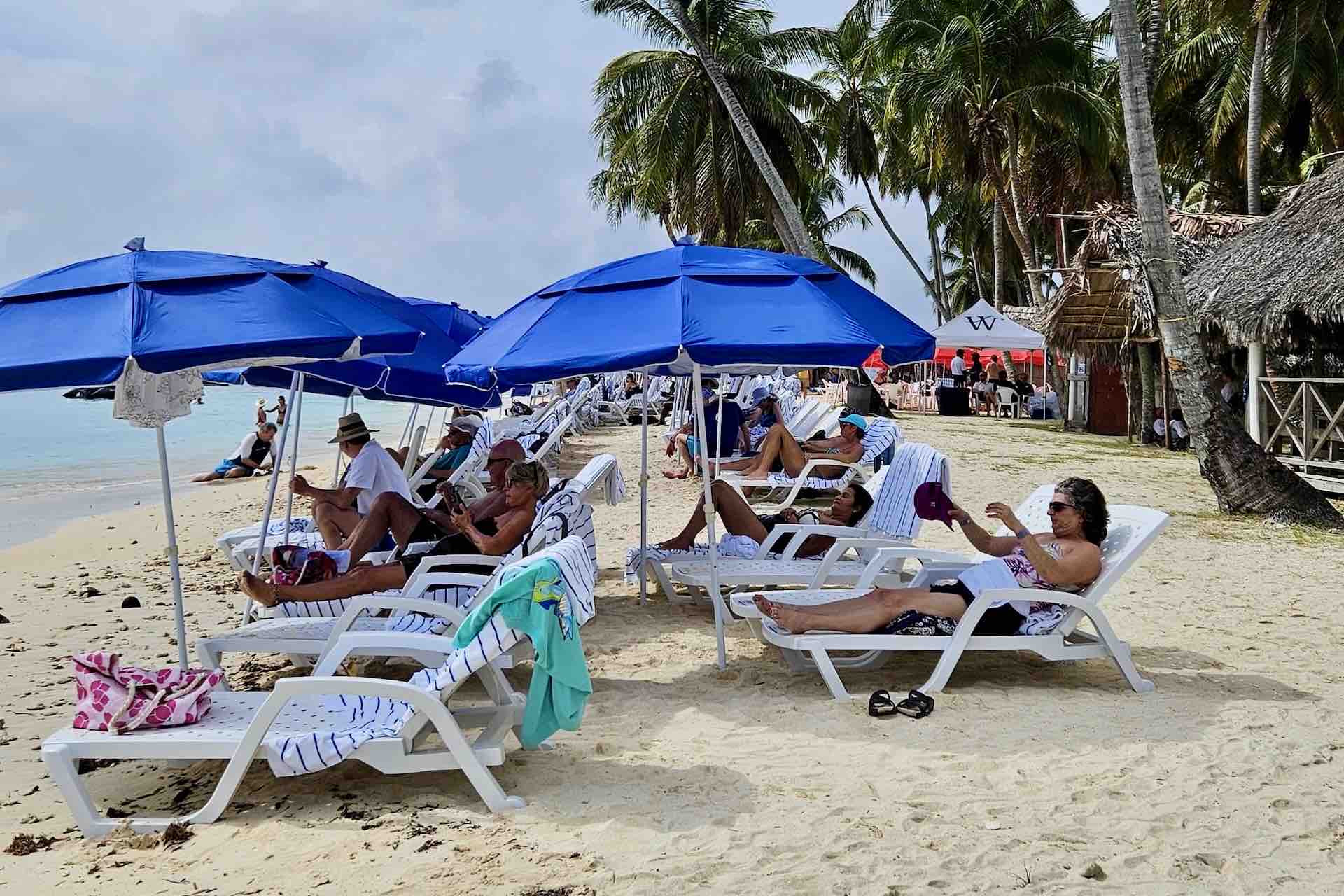 Guests relaxing on beach chairs at Isla Aroma in the San Blas Islands, Panama
