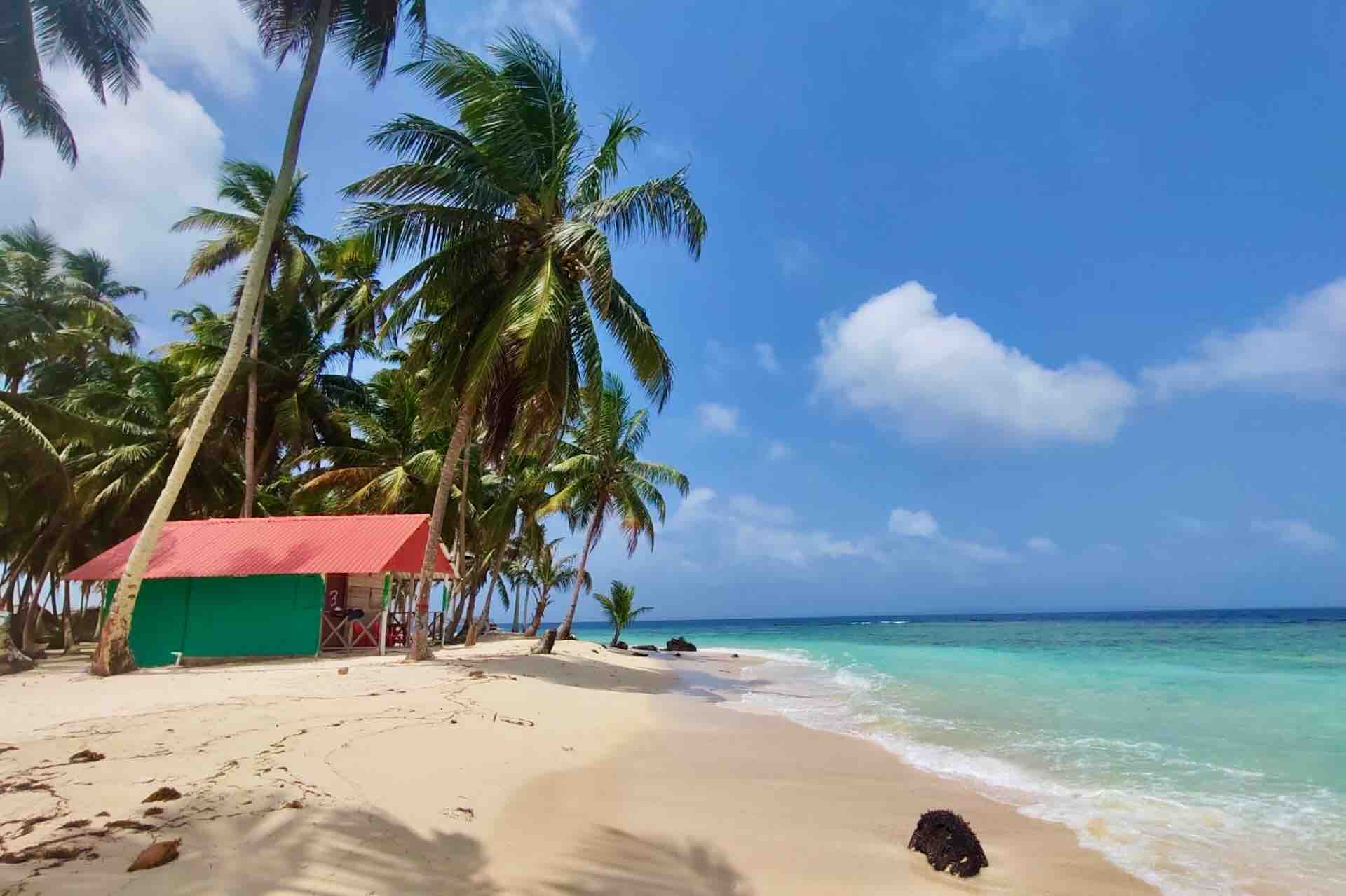 Beachfront cabin and turquoise water at Isla Asserya in the San Blas Islands