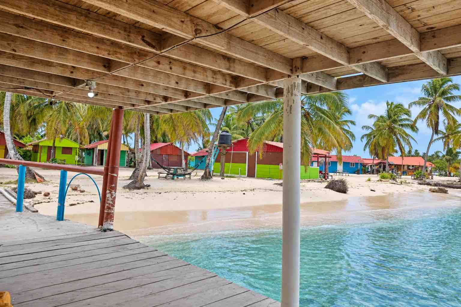 Arrival dock overlooking colorful cabins and the beach on Isla Diablo San Blas