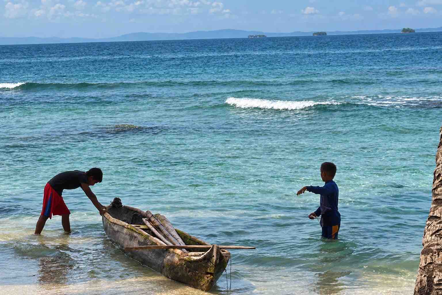Guna children with a traditional canoe near Isla Narasgandup San Blas