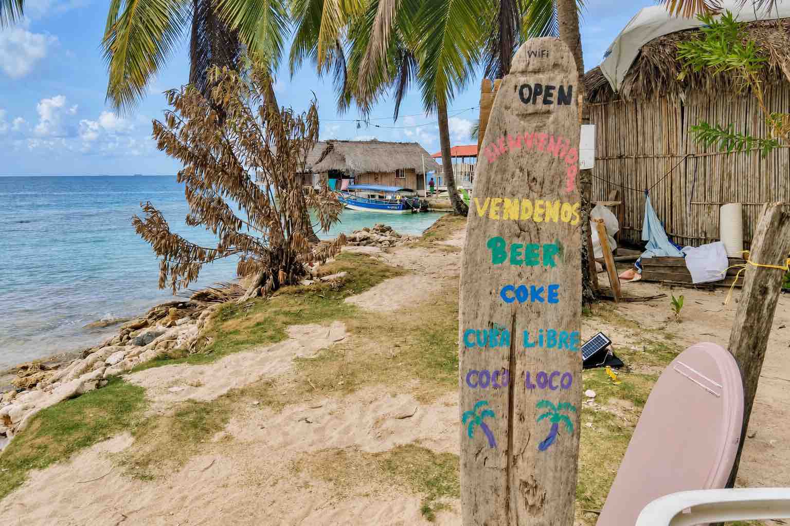 Hand-painted village sign beside the Isla Narasgandup shoreline