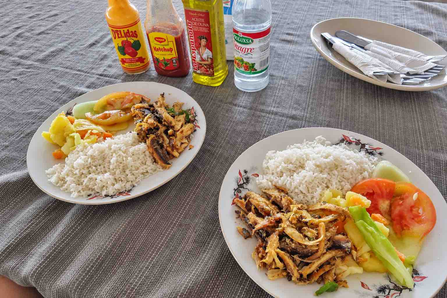 Two plates of seafood, rice and vegetables at an island restaurant