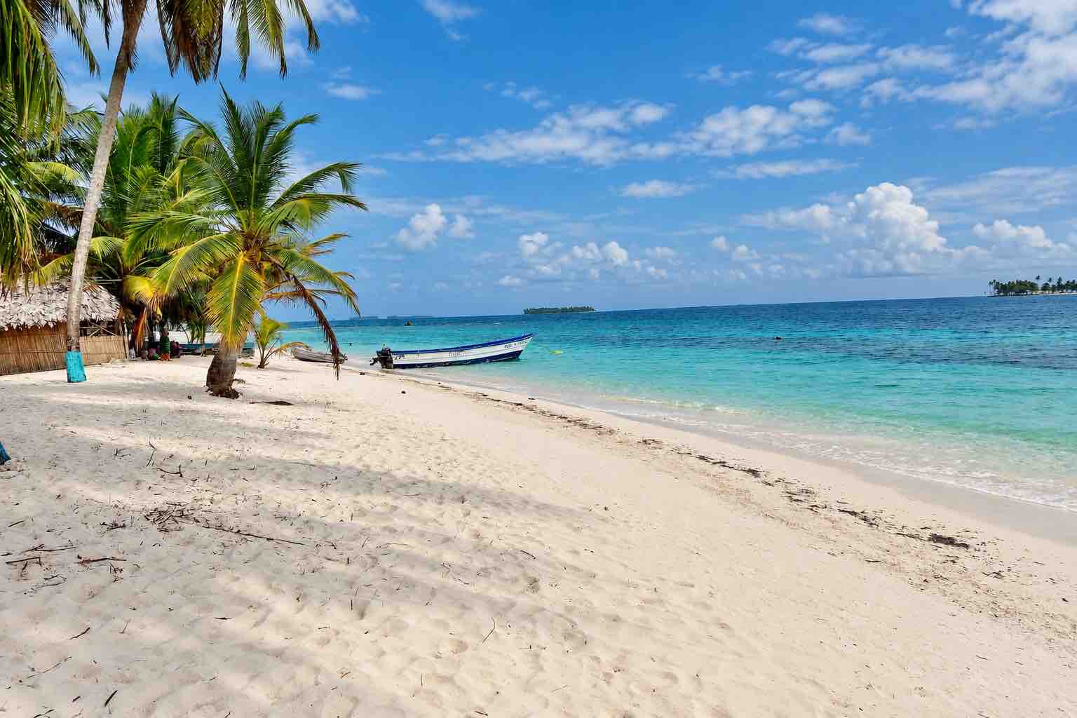 White-sand beach and boat at Isla Narasgandup San Blas