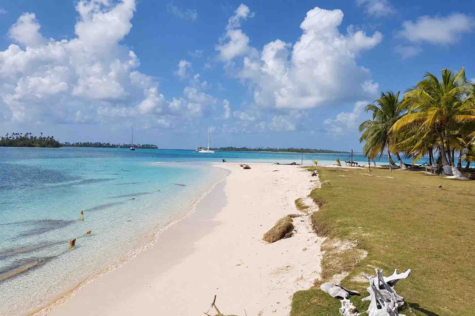 White sand beach and shallow reef waters on Isla Narasgandup