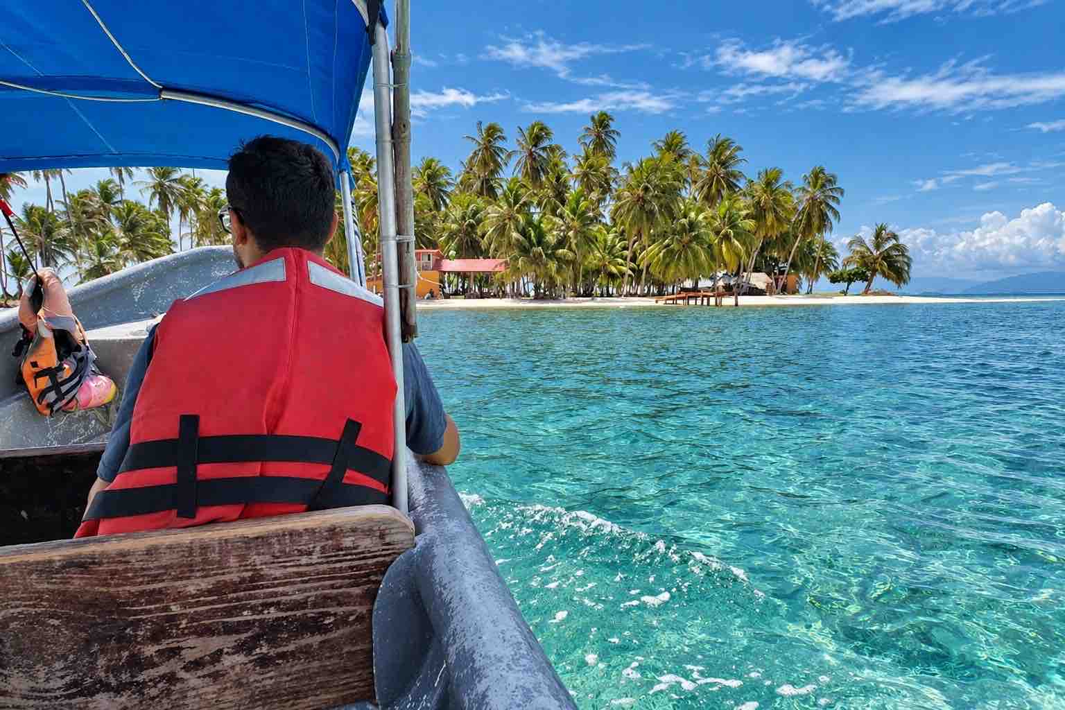 Passenger approaching a palm-covered island by boat