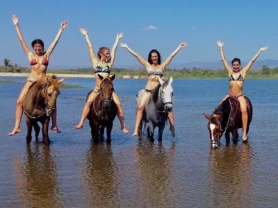 Huatulco Tours Paseo a caballo por la playa La VENTAnilla Huéspedes sentados a caballo
