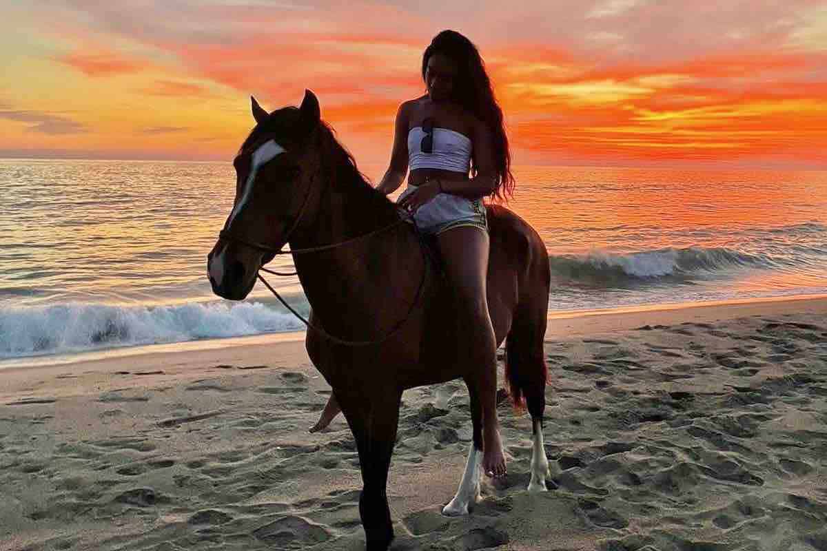 Beach Horseback riding woman in red sunset