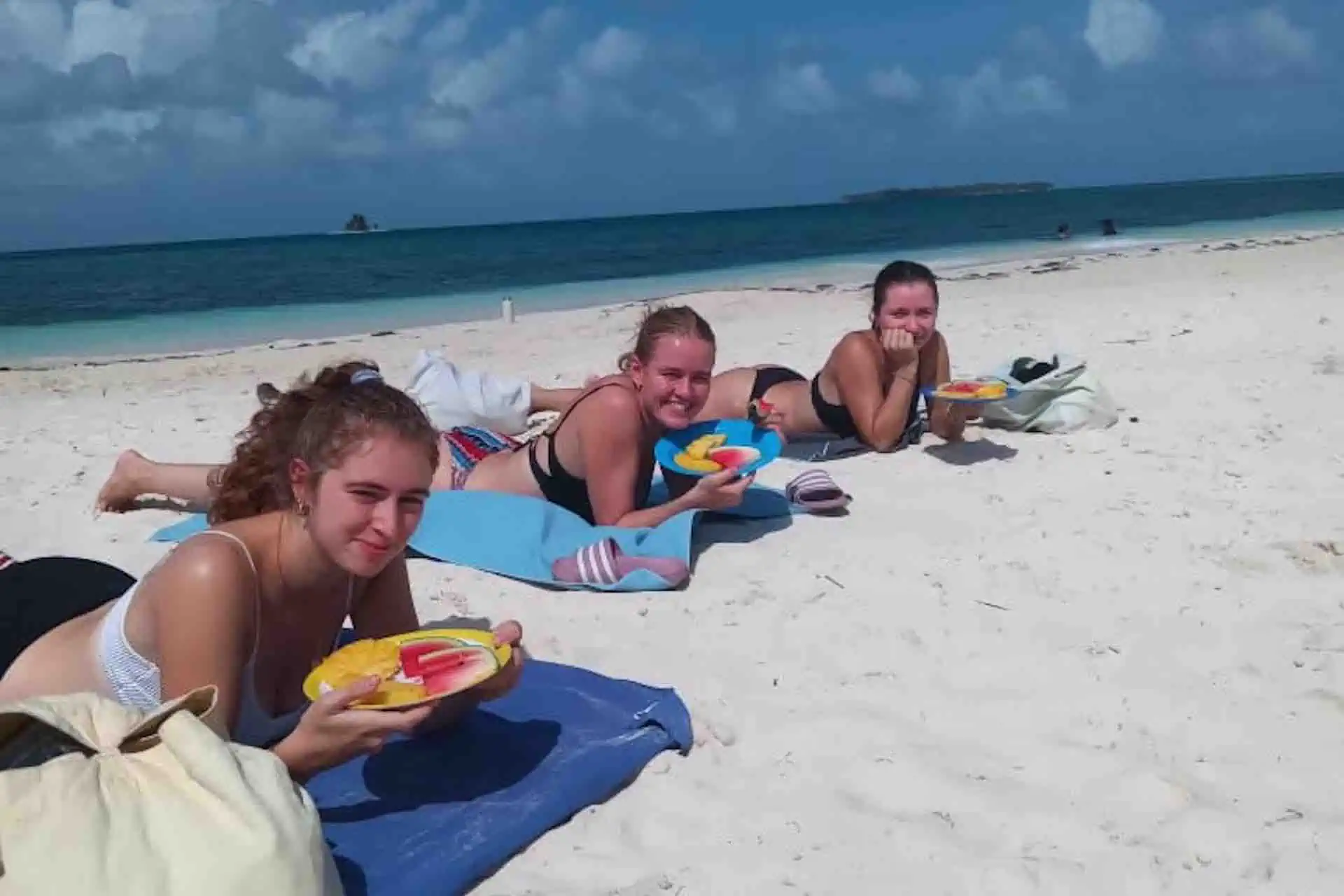 San Blas tour San Blas beach day girls lying on Perro beach eating fruit