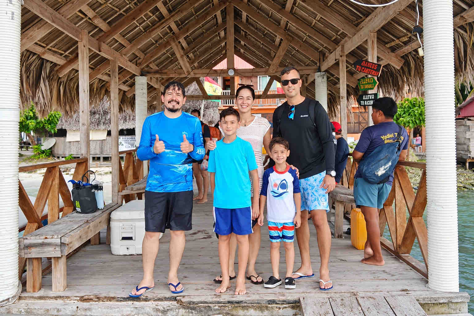 Family and guide posing inside a thatched island restaurant during a San Blas beach trip