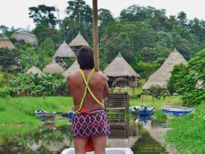 indigenous Embera man standing on boat looking at his village during tour