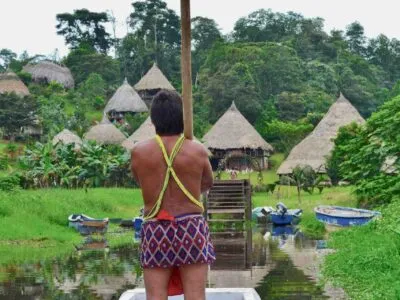 Embera Panamá Indian Village tour hombre de pie en un barco mirando su pueblo durante el tour paquetes de vacaciones en Panamá