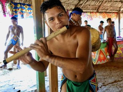 Embera Panama tribe man playing flute during tour