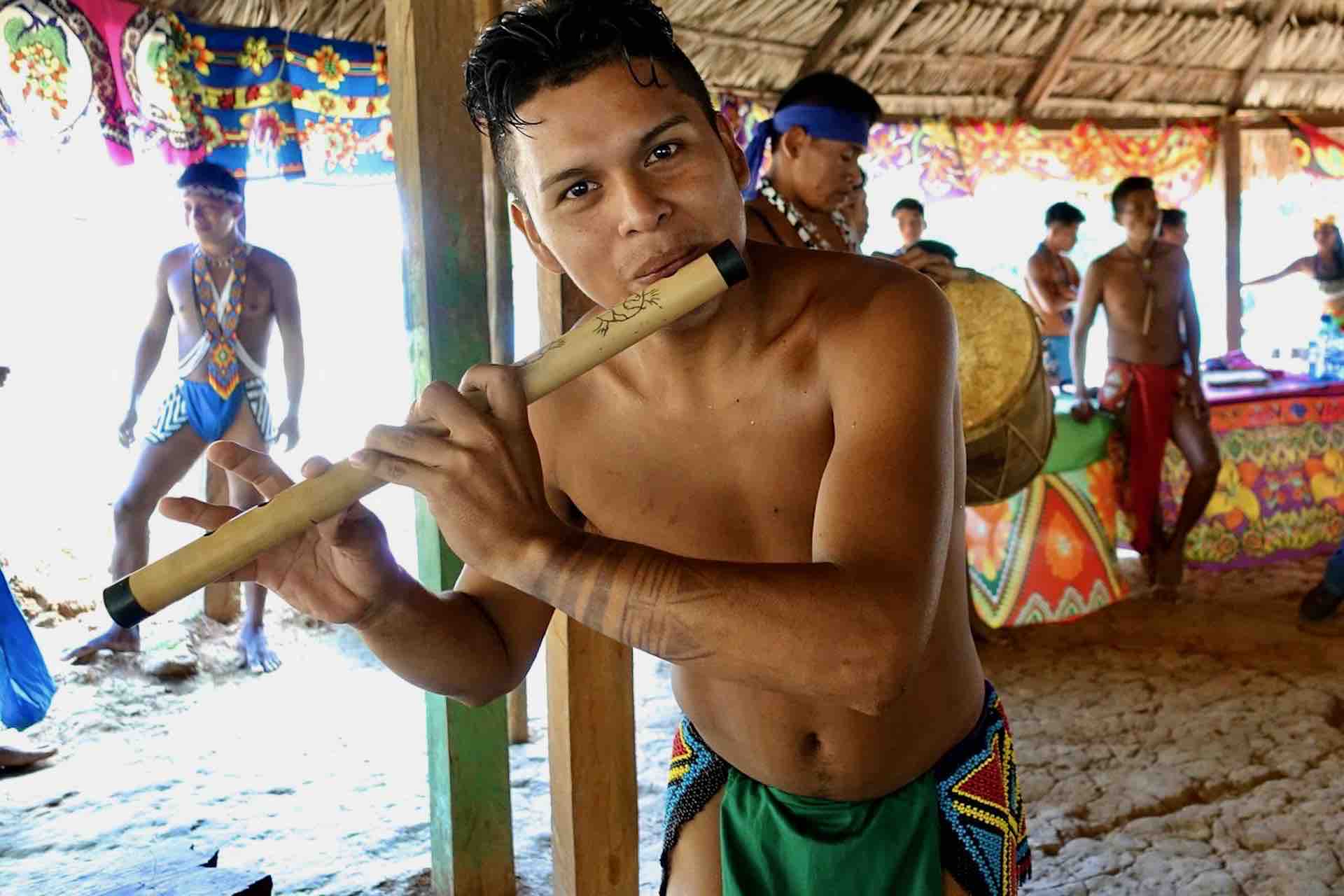 Embera Panama tribe man playing flute during tour