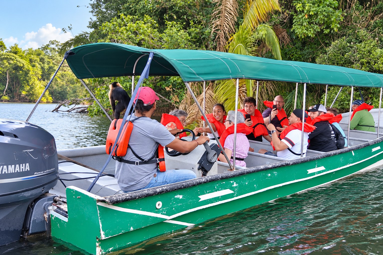 Monkey Island Boat Tour Panama – Container Ship View Monkey Island boat tour Panama: Guests in a green covered boat with a capuchin near the canopy