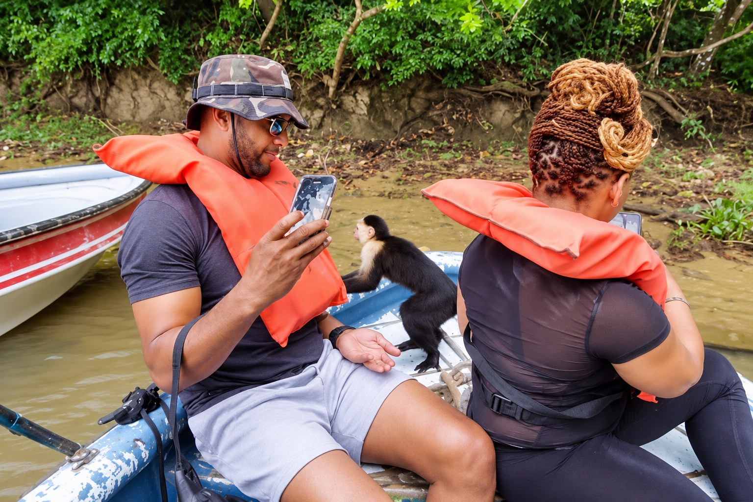 Monkey Island Boat Tour Panama – Monkeys Near Two Visitors Monkey Island boat tour Panama: Two visitors watching monkeys near their boat seats
