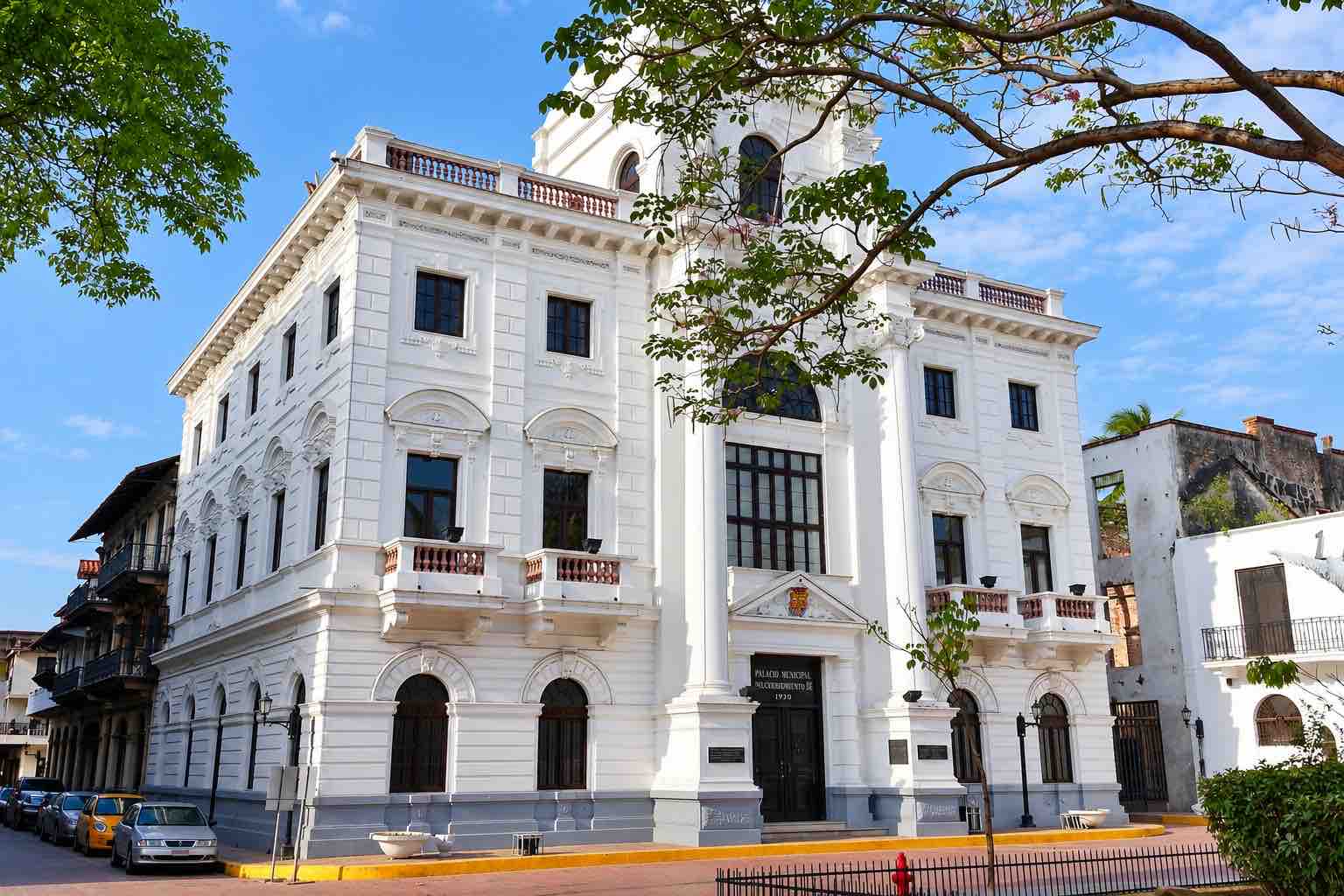 Panama Canal and City Tour: white historic building framed by tree branches in Casco Antiguo.
