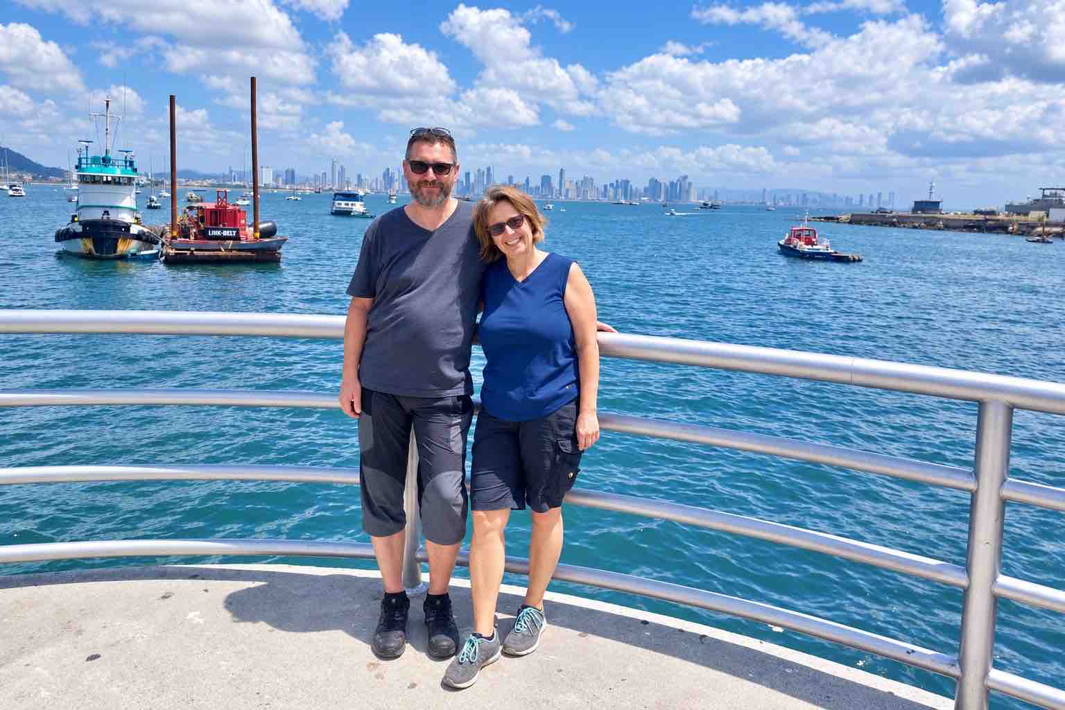 Panama Canal and City Tour: a couple beside a waterfront railing with boats and the Panama City skyline behind them.