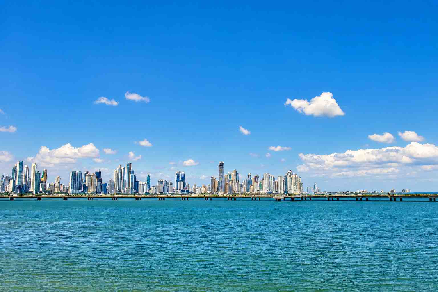 Panama Canal and City Tour: panama City skyline across the water beneath a blue sky.