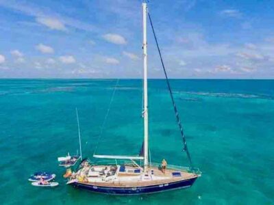 drone view of sailboat in turquoise ocean