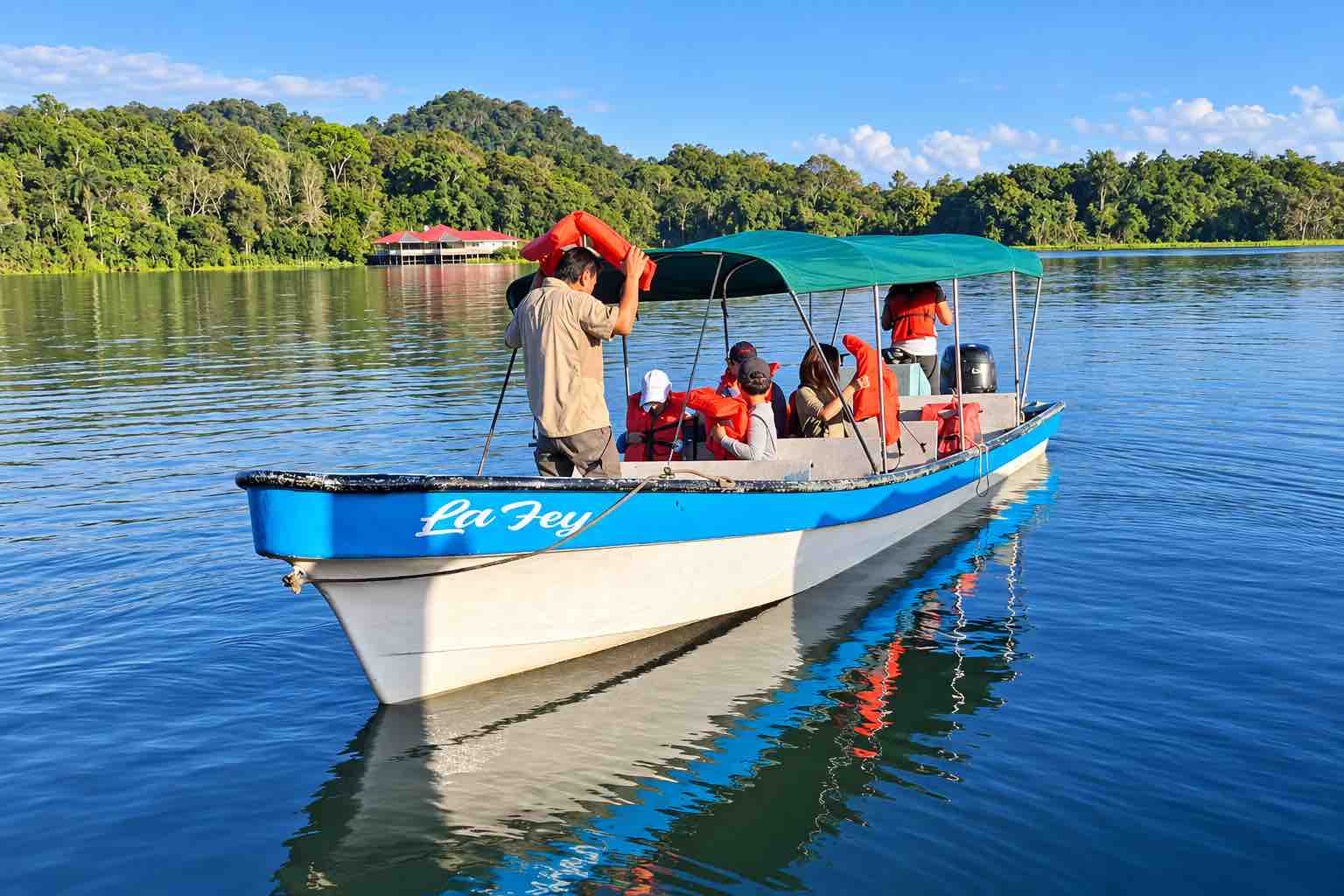 Monkey Island Boat Tour on Gatun Lake Panama Guests preparing for a Monkey Island Panama tour aboard a covered boat beside the rainforest shoreline