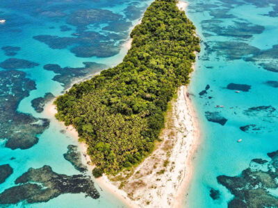 Zapatilla Island Tour Aerial Reef Aerial view of a forest-covered Zapatilla island surrounded by beaches and reef shallows.