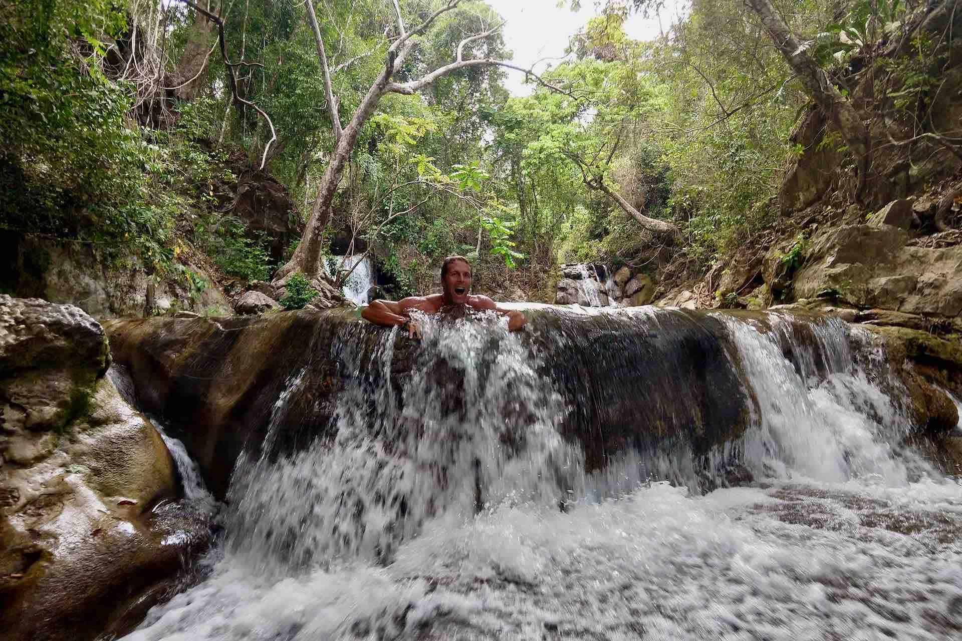 Huatulco waterfalls tour man relaxing in waterfall stream