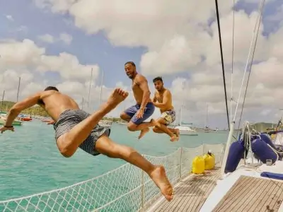 Caribbean sailboat tour guests jumping into the water