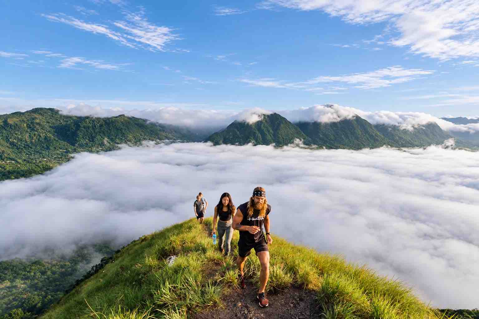 Home Elementor 27 Three hikers walking along a grassy ridge above low clouds during an Anton Valley Tour
