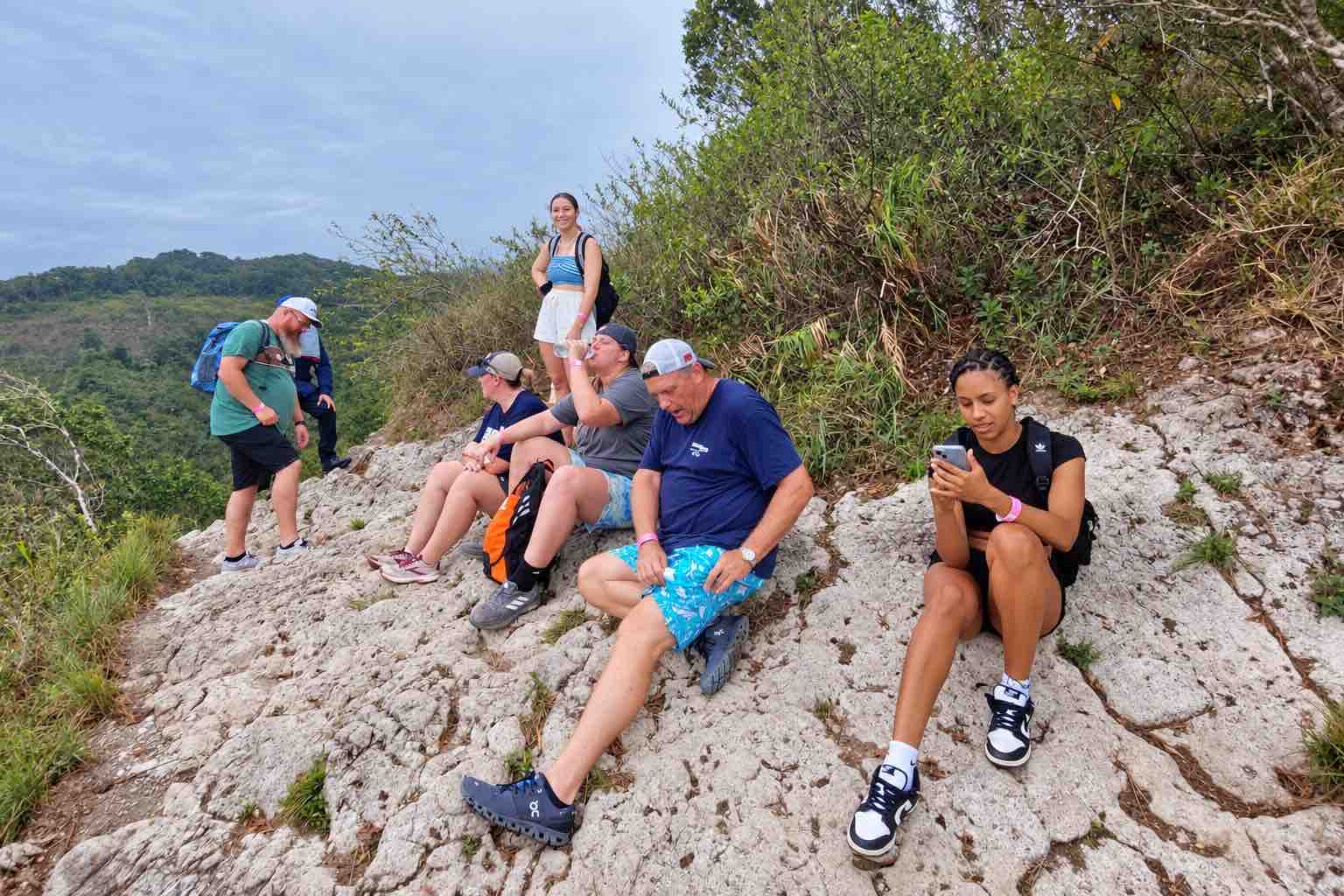 Hikers resting on a rocky viewpoint above Anton Valley