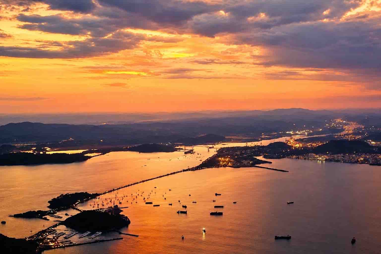 Panama helicopter tour: Aerial view of waterways, islands and anchored ships at sunset.