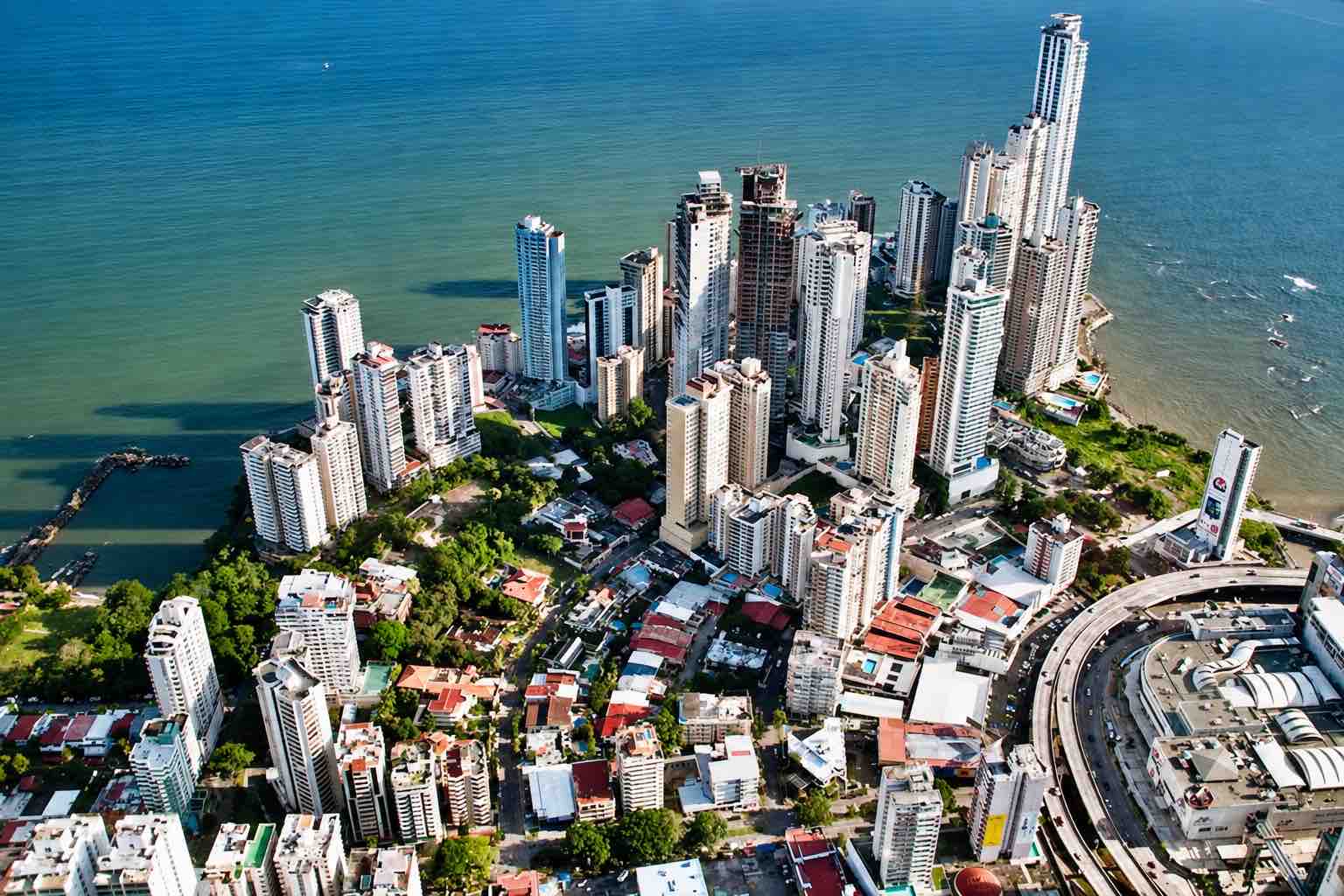 Panama helicopter tour: Aerial view of Panama City’s waterfront towers and coastal roads.