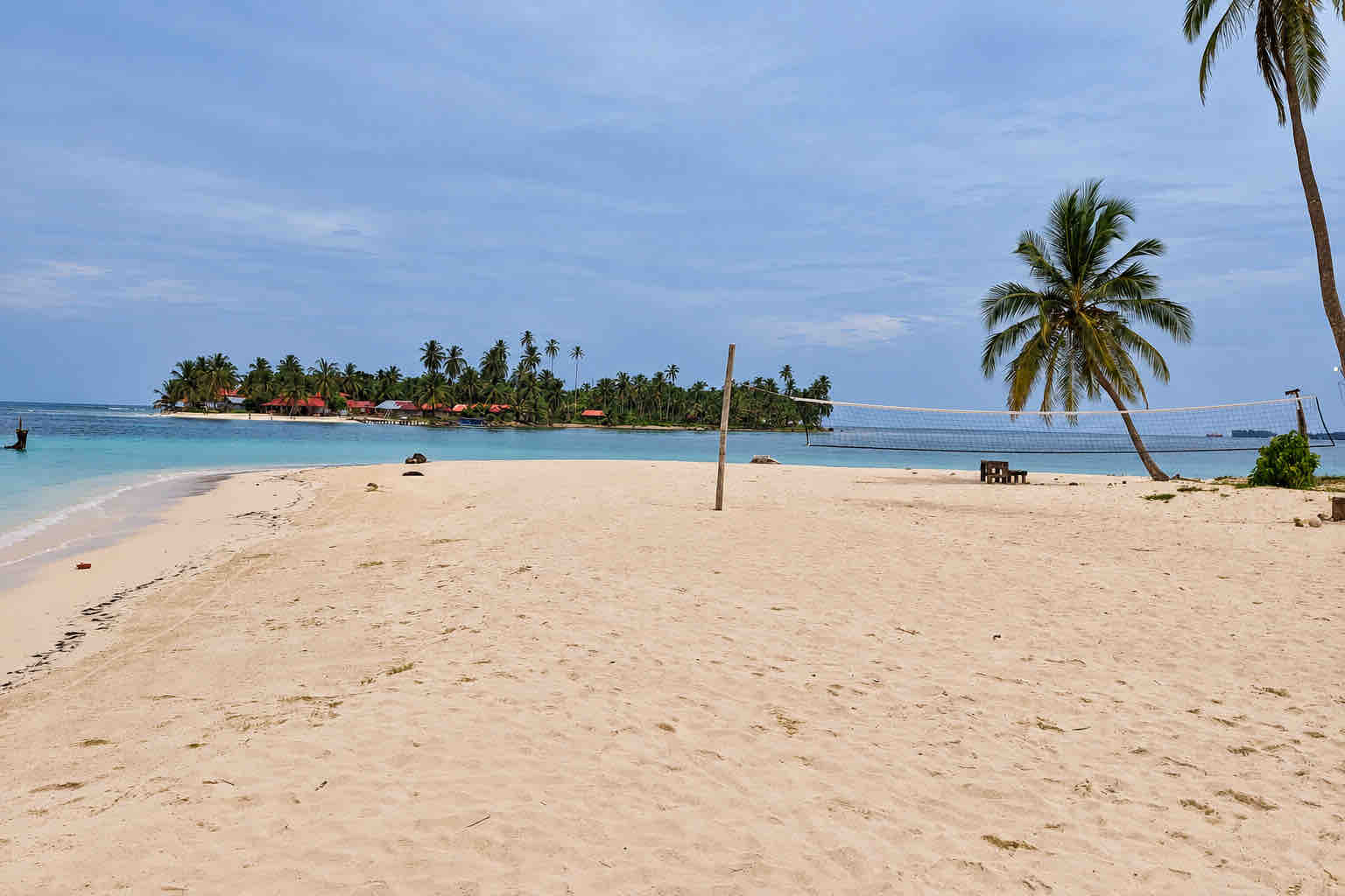 Main beach with a volleyball net and Isla Diablo across the water at Isla Perro San Blas