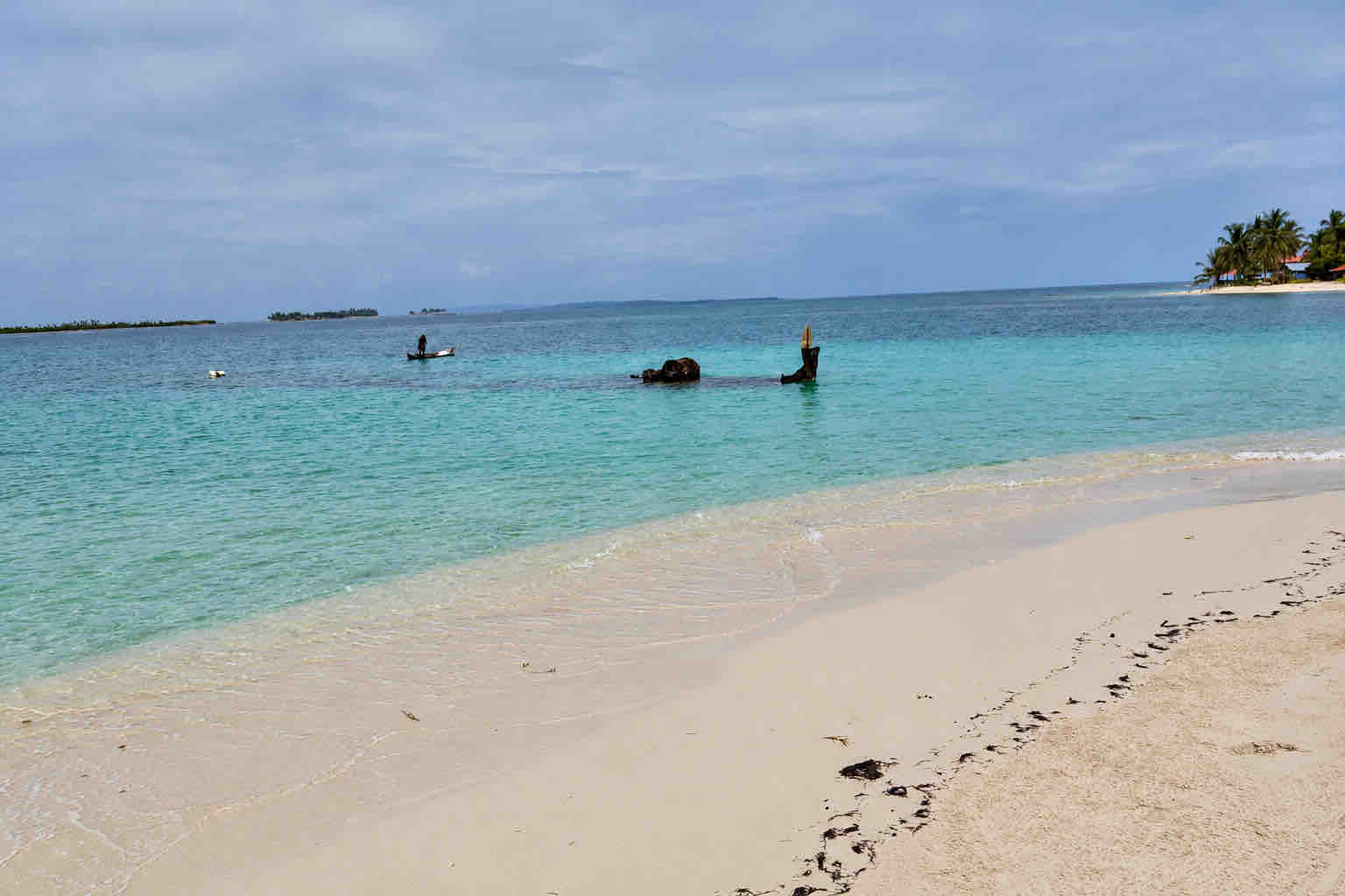 Shipwreck visible in shallow water beside the sandy beach at Isla Perro San Blas