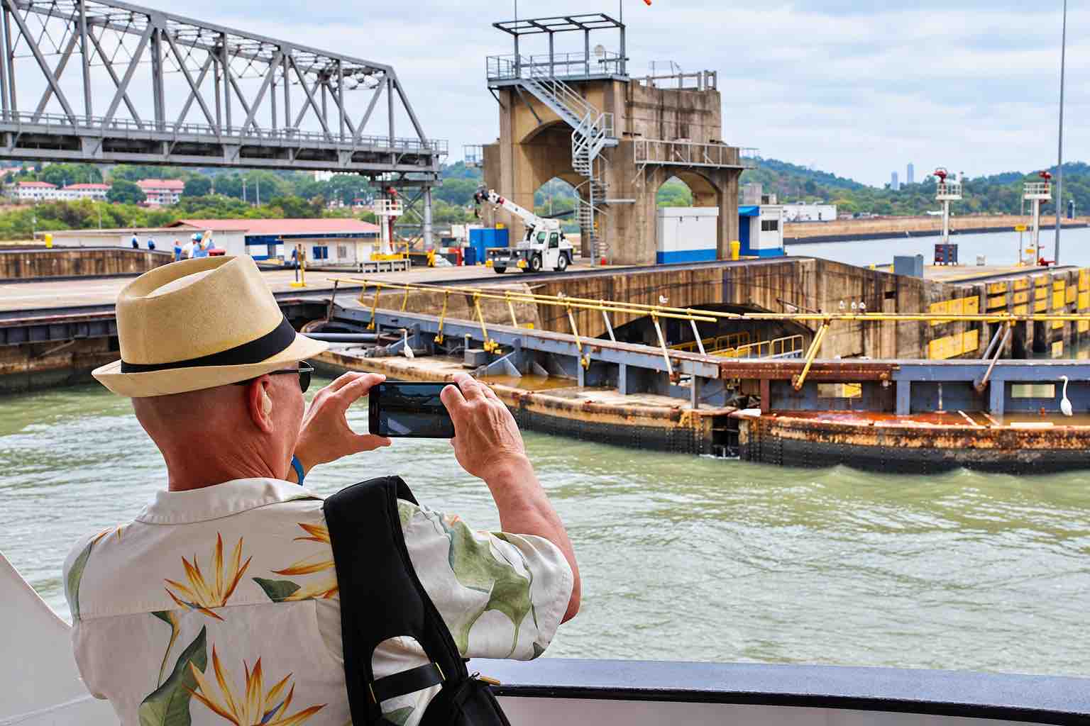 Panama Canal partial transit tour: a guest photographing canal lock structures from the Pacific Queen.