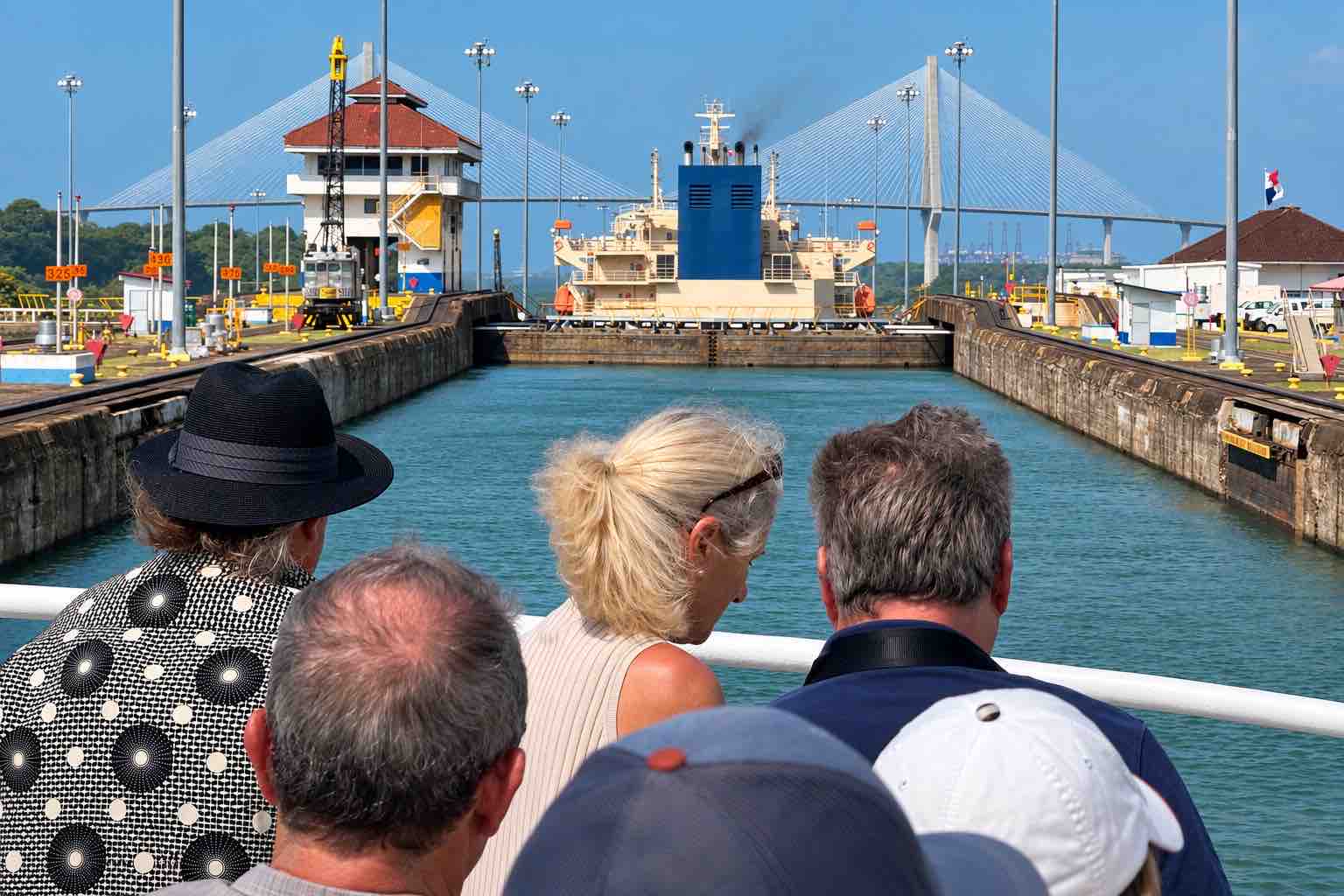 Panama Canal partial transit tour: cruise guests looking toward the canal lock gates and control building.