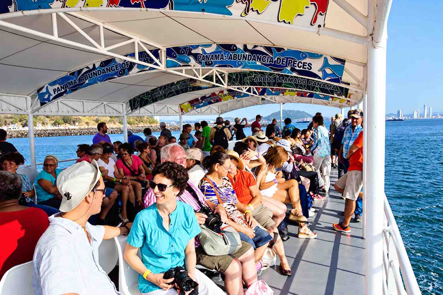 Panama Canal partial transit tour: passengers seated on the covered deck of the Pacific Queen.