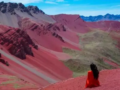 rainbow mountain red valley woman looking into distance