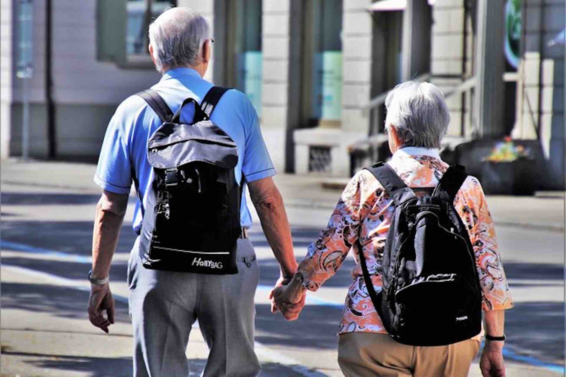 Casco Viejo Walking Tour image: couple with backpacks holding hands while walking through a city plaza