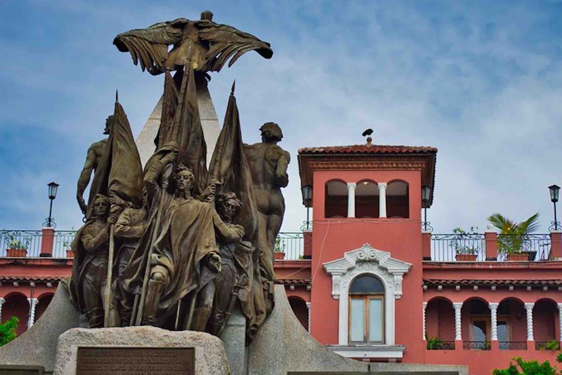 Casco Viejo Walking Tour image: sculpted monument with a red historic building behind it