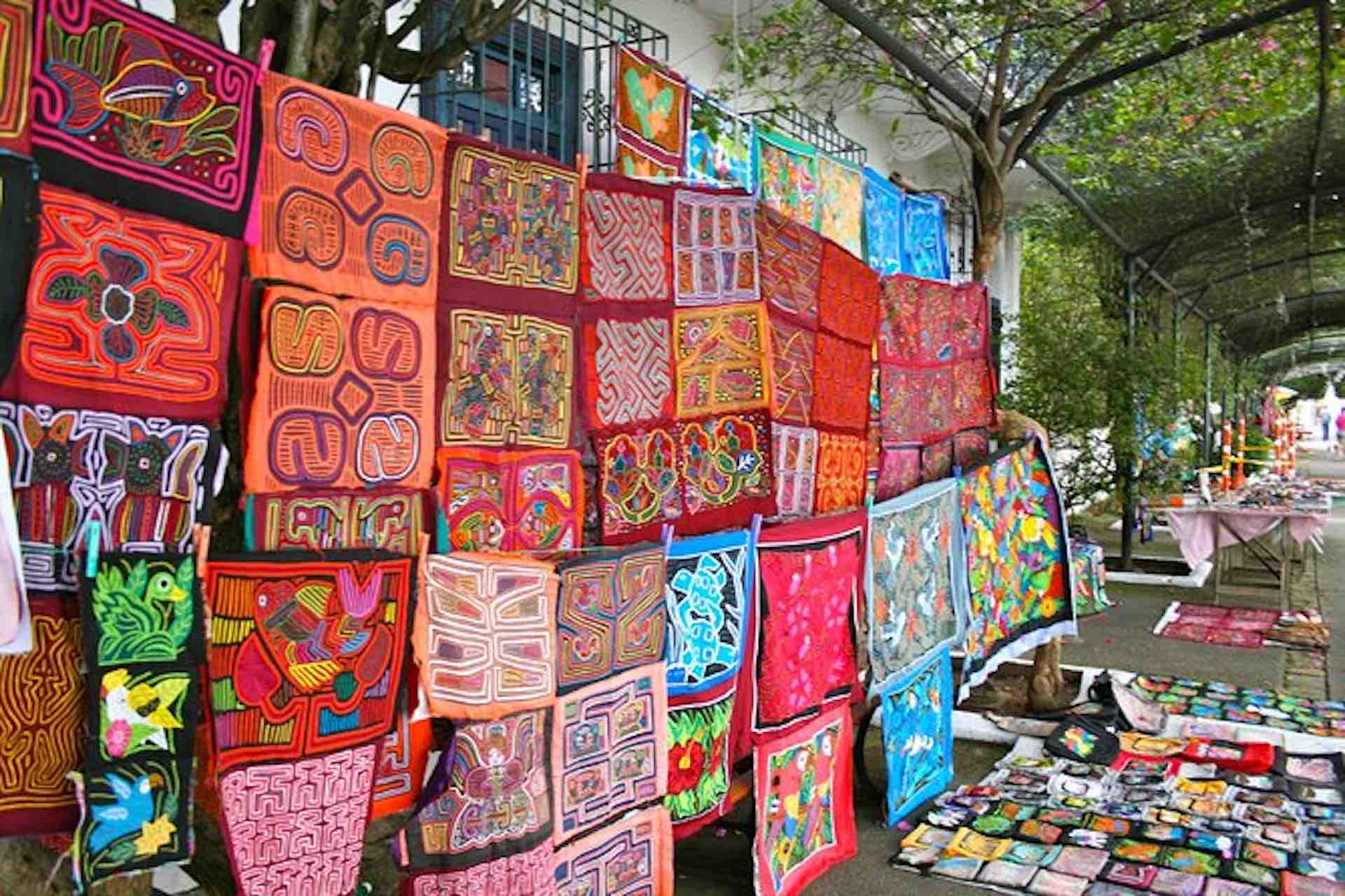 Casco Viejo Walking Tour image: brightly colored mola textiles and souvenirs displayed at an outdoor stall