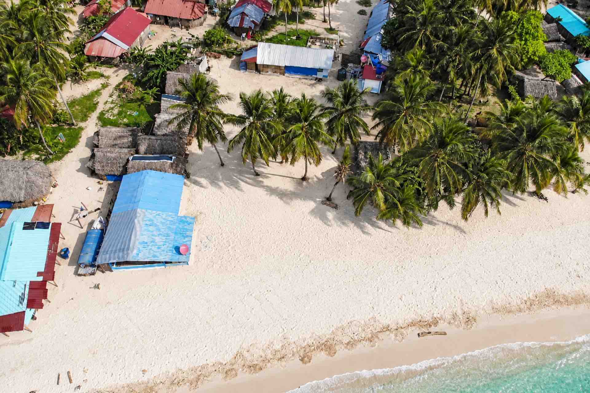 Overhead aerial view of Isla Ina beach cabins and palm trees