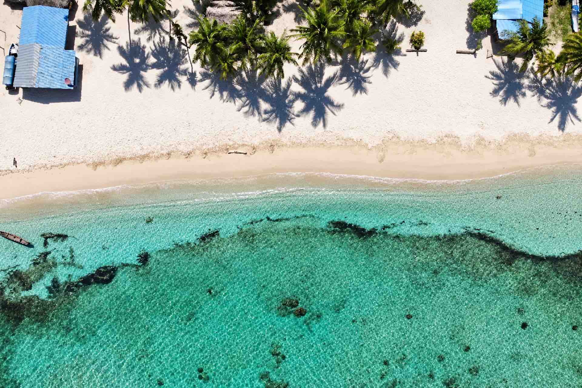 Top-down aerial view of Isla Ina beach and clear shallow water