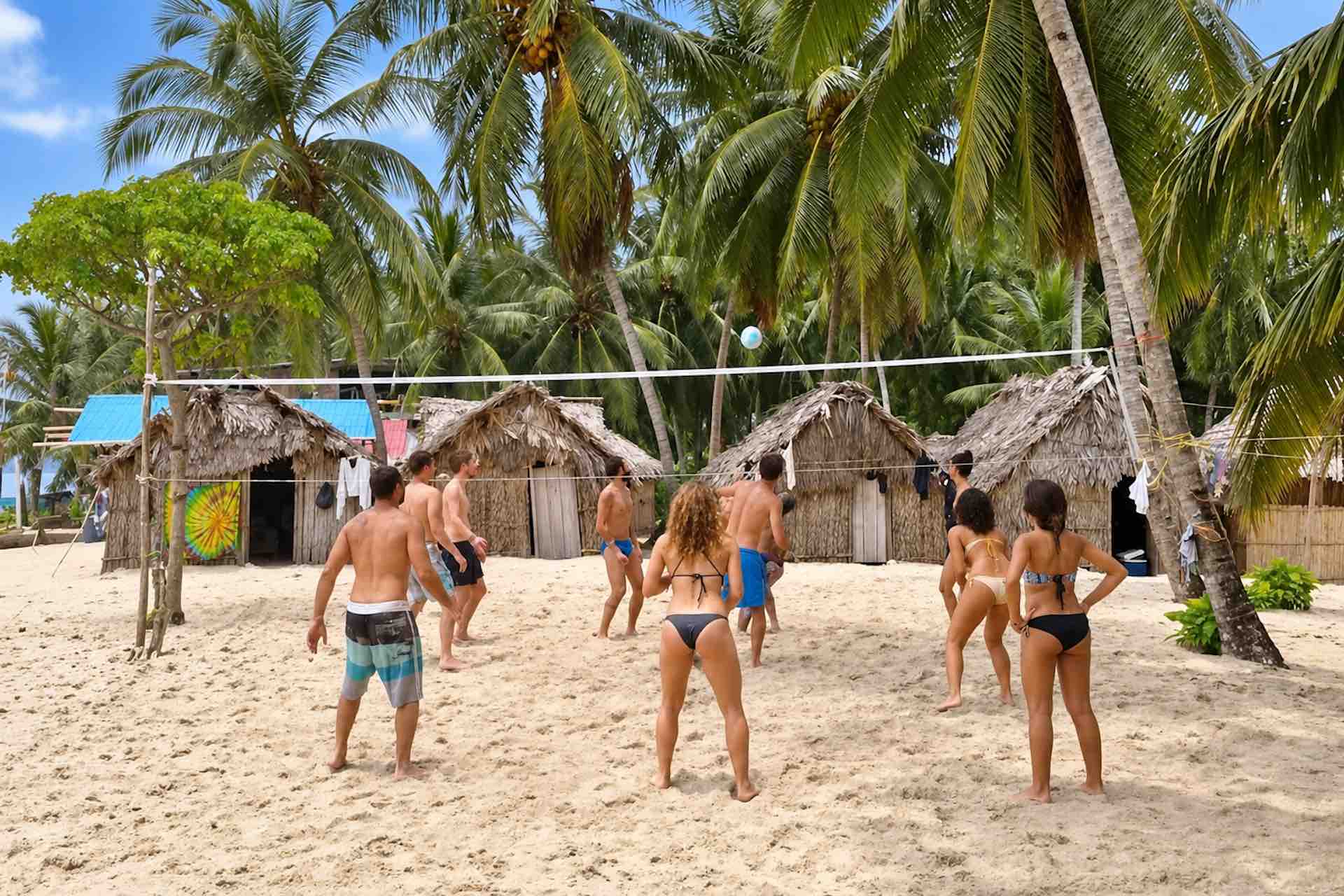 Guests playing volleyball on the sand near Isla Ina cabins