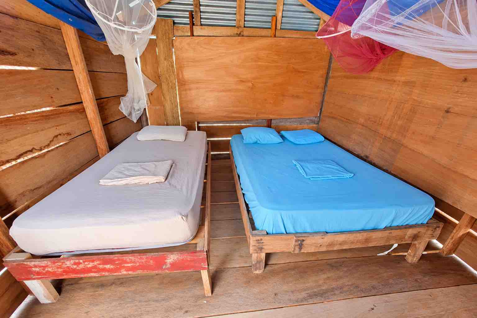 Isla Ina San Blas Private Cabin with Two Beds Two separate beds with blue and light-colored bedding inside an Isla Ina cabin